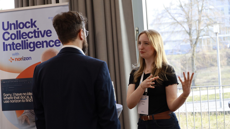 Eine Unterhaltung zwischen einer jungen Frau und einem Mann auf dem B2B-DemoDay.